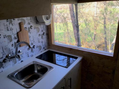 a kitchen counter with a sink and a window at Relax Container in Aguiar da Beira