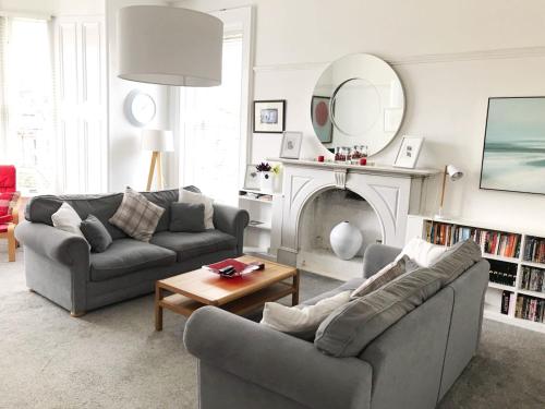 a living room with two couches and a mirror at Bishopton Apartment, near Glasgow in Bishopton