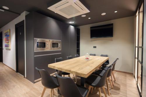 a dining room with a wooden table and chairs at Airhostel Barcelona Airport 24h in El Prat de Llobregat