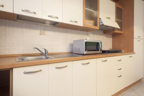 a kitchen with a sink and a microwave at La Fonte degli Angeli Apartments in Suvereto