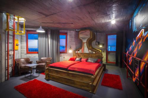 um quarto com uma cama grande e um cobertor vermelho em Hotel Kongress em Leoben