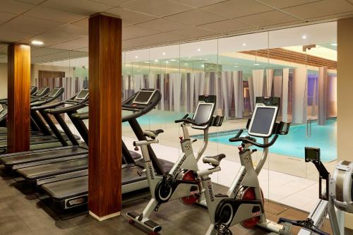 a gym with a row of exercise bikes and a swimming pool at The Landmark London in London