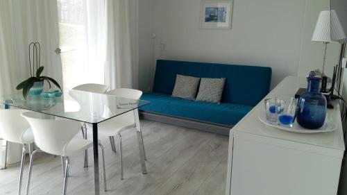 a living room with a blue couch and a table and chairs at Klif & Mechelinki in Mechelinki