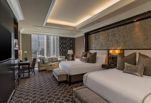 een hotelkamer met 2 bedden en een bank bij The Post Oak Hotel in Houston