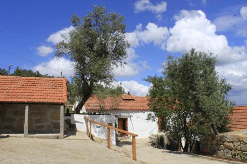 a house with two trees and a building at Casa de Santa Cristina in Alpendurada
