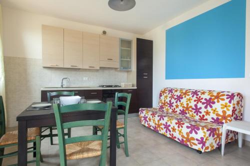 a kitchen and a living room with a table and a couch at La Fonte degli Angeli Apartments in Suvereto