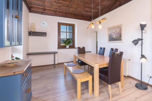 a kitchen and dining room with a wooden table and chairs at Pension Rudolfshöhe in St. Wolfgang