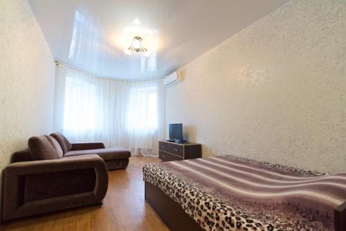 ヴォルゴグラードにあるApartment on Parkhomienko 8のベッドルーム(ベッド1台、椅子、テレビ付)
