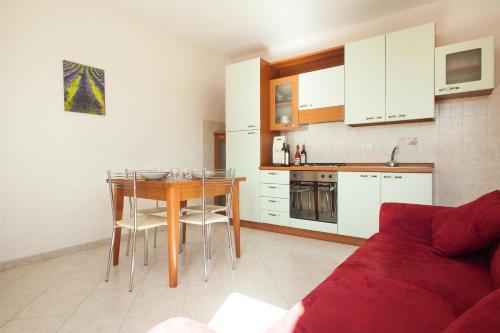 a kitchen with a table and a red couch at La Fonte degli Angeli Apartments in Suvereto