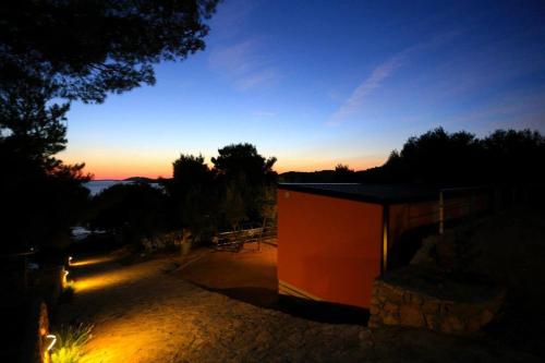 a view of a building with the sunset in the background at Mobile homes-Slanica in Murter