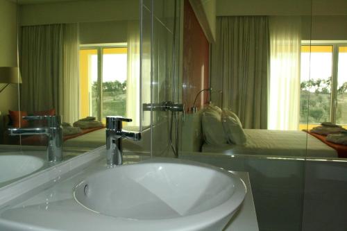 a bathroom with a sink and a large mirror at Monte Filipe Hotel in Alpalhão