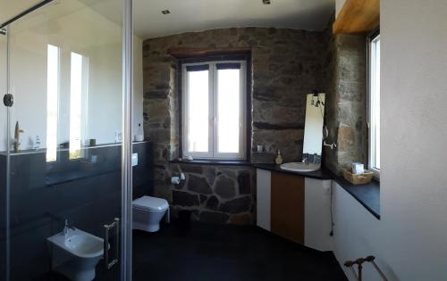 a bathroom with a sink and a toilet and a window at Quinta Quatro Ventos in Sertã