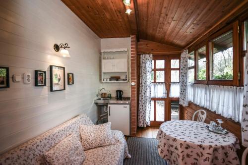 a living room with a table and a kitchen at Garten Vendégház in Eger