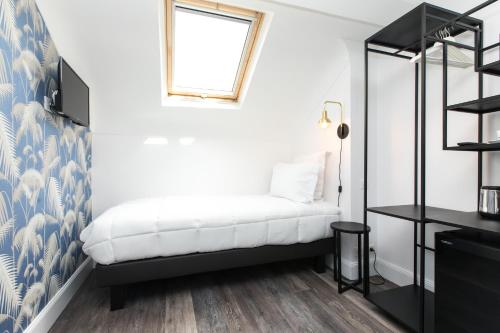 a bedroom with a bed and a window at Arome Hôtel in Nice