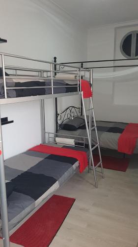 1 Schlafzimmer mit 2 Etagenbetten und einer Leiter in der Unterkunft Lisbon Hostel Terminal 3 in Lissabon