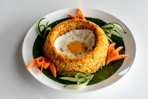 a plate of food with an egg in a bowl at Montgomerie Links Hotel & Villas in Hoi An