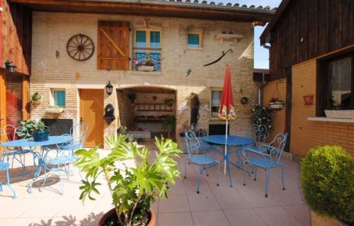 un patio con mesas y sillas y un edificio en Le pigeonnier, en Dampierre-le-Château