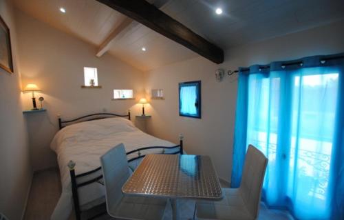 a bedroom with a bed and a table and chairs at Le pigeonnier in Dampierre-le-Château