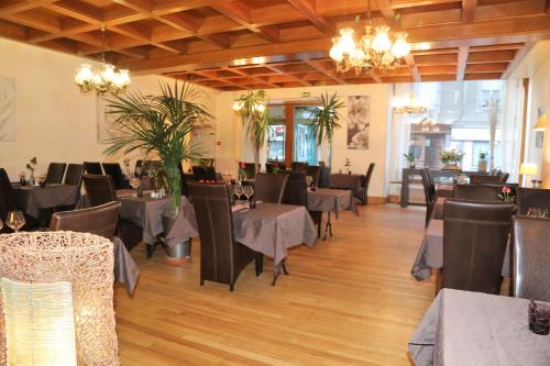 un restaurante con mesas y sillas en una habitación en Logis L'Ecu De France en Mauriac