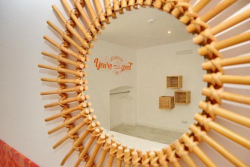 a mirror with wooden sticks in front of a bathroom at Son of a Beach Hostel in Albufeira