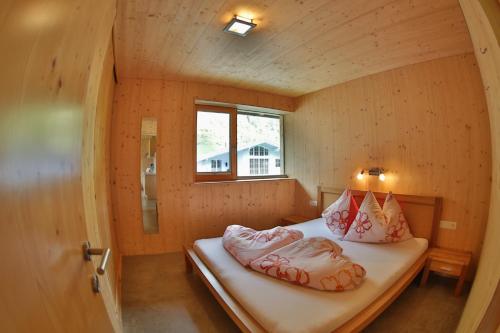 ノイシュティフト・イム・シュトゥーバイタールにあるBioholzhaus Haslingerの窓付きの小さな部屋のベッド1台分です。