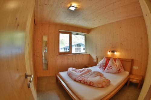 Bett in einem kleinen Zimmer mit Fenster in der Unterkunft Bioholzhaus Haslinger in Neustift im Stubaital