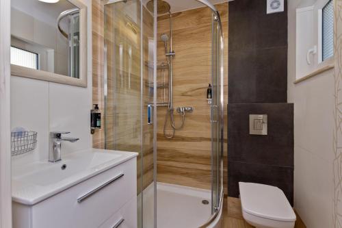 a bathroom with a shower and a toilet and a sink at Domki OAZA in Ostrowo