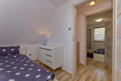 a small bedroom with a bed and a dresser at Domki OAZA in Ostrowo