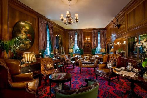 a living room with furniture and a chandelier at The Chesterfield Mayfair in London