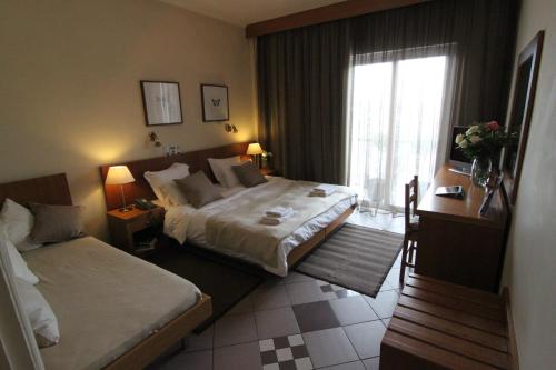 Un pat sau paturi într-o cameră la Achillion Hotel