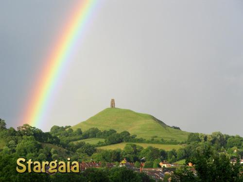 a rainbow over a hill with a tower on top at Stargaia Retreat in Glastonbury