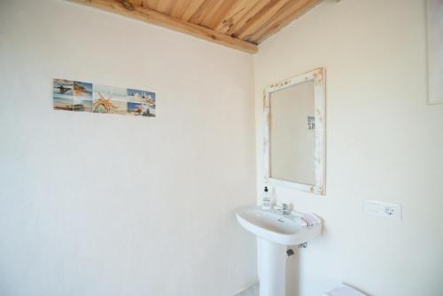 a white bathroom with a sink and a mirror at Es Mitja Davall in Sencelles