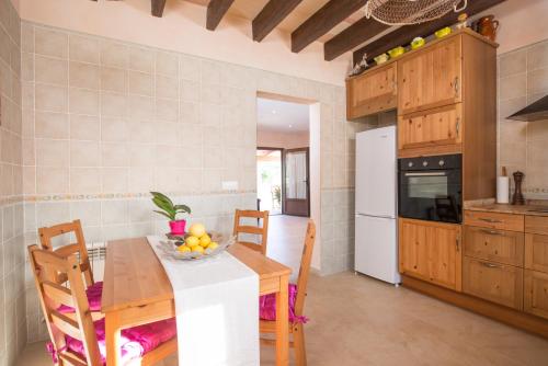 a kitchen with a table and chairs in a room at Es Mitja Davall in Sencelles