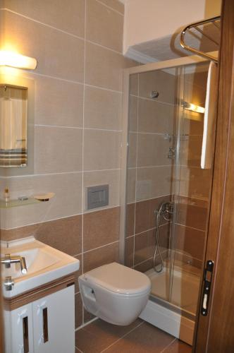 a bathroom with a shower and a toilet and a sink at Perla Hotel in Dikili