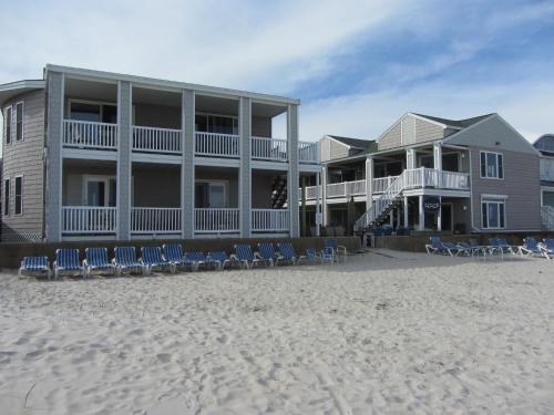 a house on the beach with chairs on the sand at Ocean Walk Hotel in Old Orchard Beach