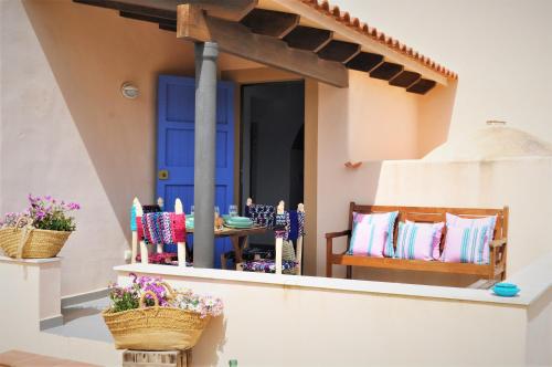 een terras met een blauwe deur en stoelen op een veranda bij Siamoformentera Alessandra in Sant Francesc Xavier