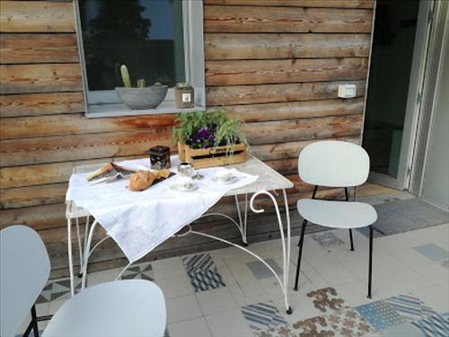 einen weißen Tisch und Stühle auf einer Terrasse in der Unterkunft Via Dei Dori B&B in Mirano