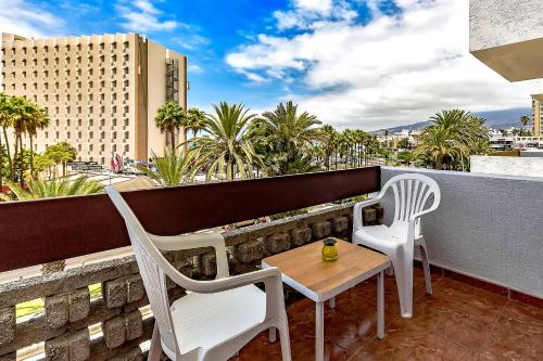 a patio with two chairs and a table on a balcony at Central Los Americos Apartment in Arona