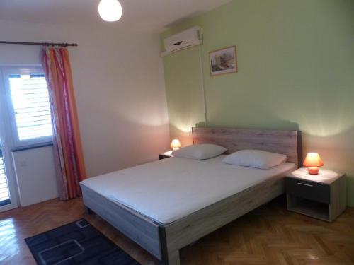 ein Schlafzimmer mit einem Bett und zwei Lampen an Tischen in der Unterkunft Apartments Smiljana in Omiš