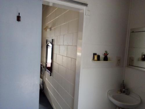 a white bathroom with a toilet and a sink at Redwood Lodge Motel in Levin
