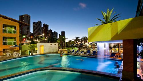 a swimming pool with a city skyline in the background at Natal Praia Hotel in Natal