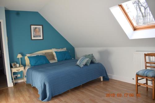 1 dormitorio con 1 cama con pared azul en Les Tilleuls en Ballan-Miré