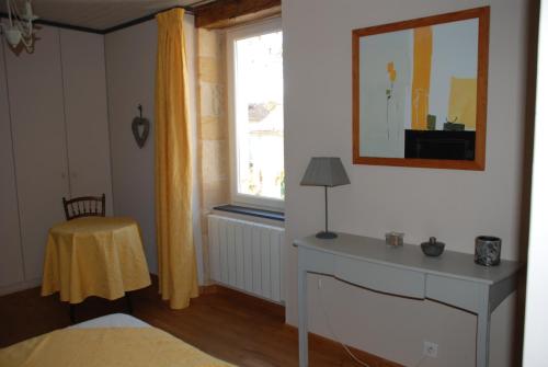 a bedroom with a bed and a window and a table at Maison d' hôtes individuelle La Relinquière in Milhac