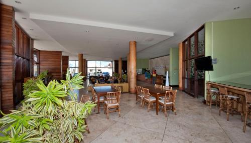a lobby with chairs and tables and a bar at Natal Praia Hotel in Natal