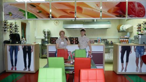 ヴォロコラムスクにあるHotel on Porokhovskayaの二人の女性がカラフルな椅子付きの台所に立っている