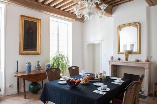 une salle à manger avec une table et une cheminée dans l'établissement Aux Portes d'Honneur, à Cluny