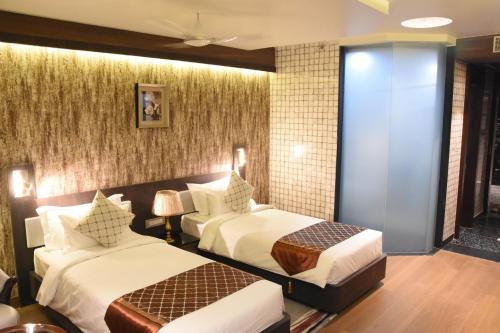 a hotel room with two beds in a room at Costa Riviera Hotel in Varanasi