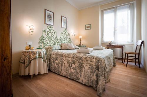 Schlafzimmer mit einem Bett, einem Tisch und einem Fenster in der Unterkunft Santa Felicita Apartments in Florenz