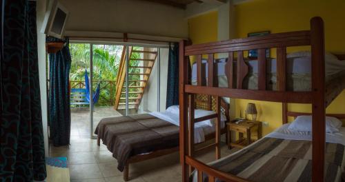 a bedroom with two bunk beds and a balcony at Hostal moai in Montañita
