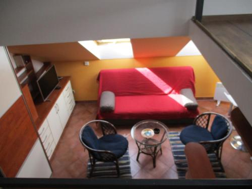 a small room with a red bed and chairs at Apartment Sonja in Belgrade